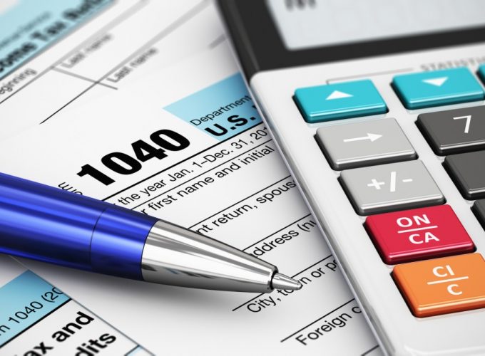 Macro view of 1040 US Tax Form, calculator and ballpoint pen